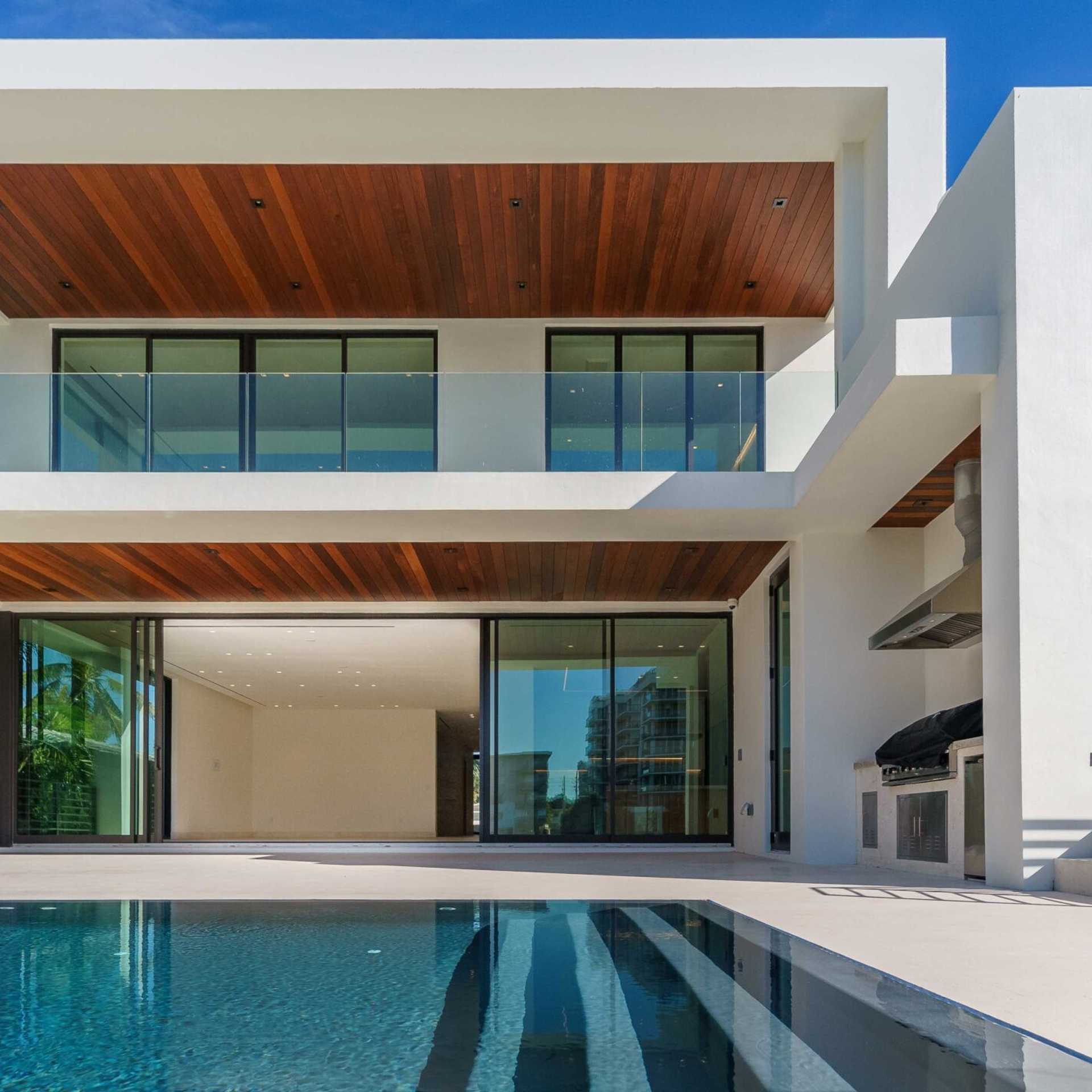 Exterior view of a modern house showcasing unique architecture, an infinity pool, and built in cooking station.