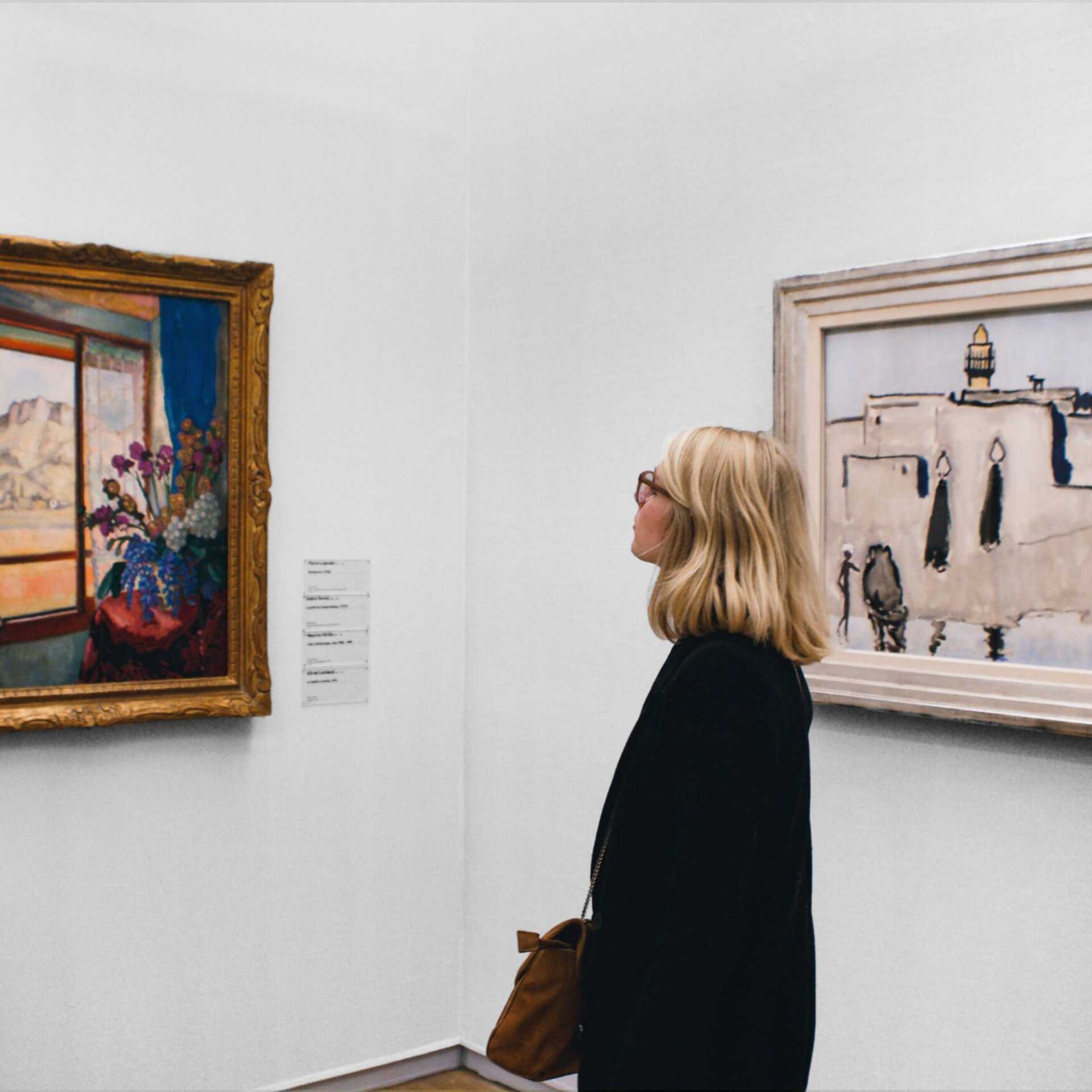 A woman looking at fine art in a museum.