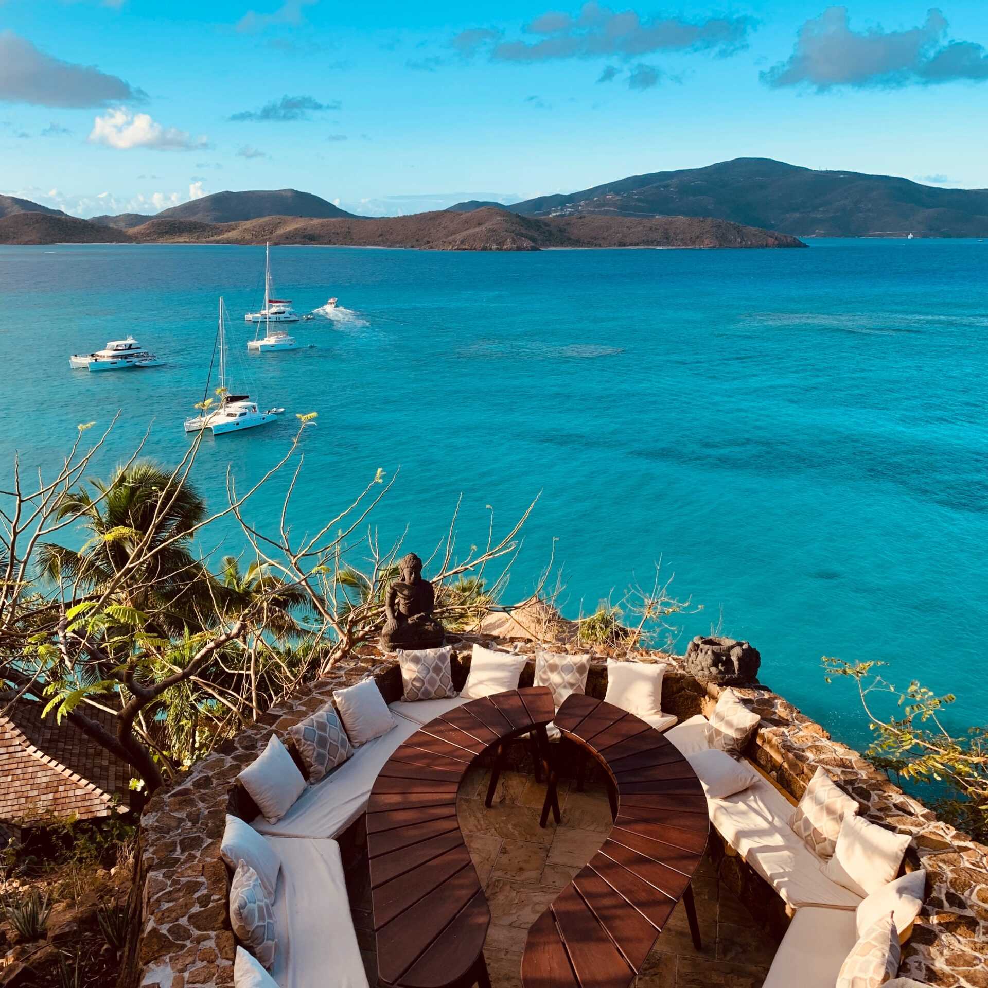 A private patio overlooking a crystal blue sea with private yachts.